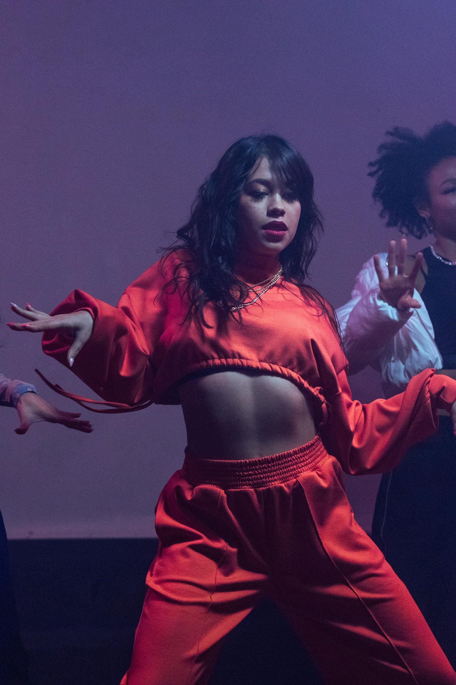 Dynamic indoor shot of women dancing in vibrant outfits, expressing hip hop style.